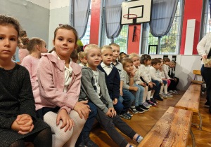 Dzieci siedzą na ławkach