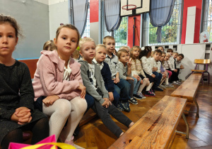 Dzieci siedzą na ławkach