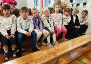Dzieci siedzą na ławkach