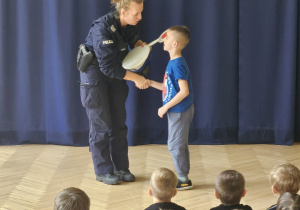 Chłopiec wita się z policjantką