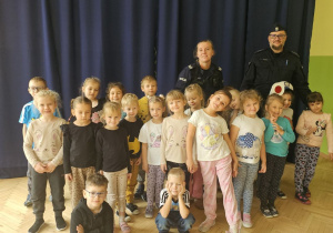 Dzieci z grupy 4 pozują do zdjęcia z policjantami
