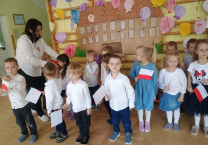 Dzieci stoją w strojach galowych