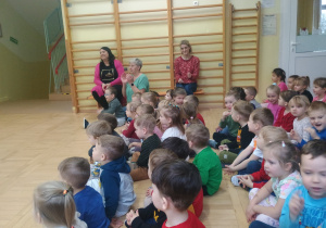 Dzieci słuchają muzyki granej na gitarze elektrycznej