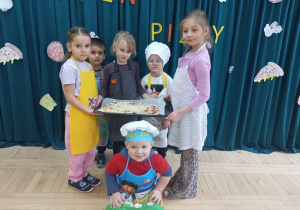 Dzieci pokazują wykonaną przez siebie pizzę