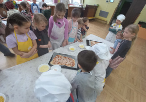 Dzieci układają składniki na pizzę