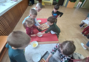 Dzieci pospują pizzę żółtym serem