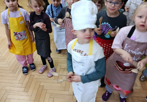 Dzieci wystukująja rytm drewnianymi łyżkami