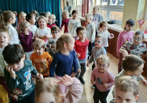 Dzieci uczestniczą w pląsach na sali gimnastycznej