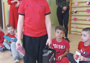 Chłopiec częstuje dzieci walentynkowymi lizakami