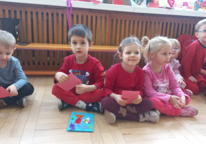 Dzieci siedzą trzymając walentynki