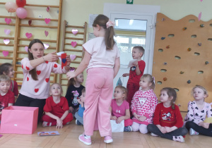 Nauczycielka daje dzieciom walentynki
