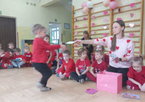 Prowadząca wręcza chłopcu walentynkę