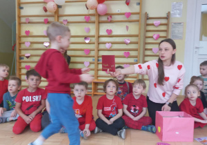 Nauczycielka wyjmuje walentynki z pudełka i rozdaje dzieciom