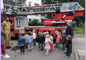 Grupa I i II stoją przy wozie strażackim
