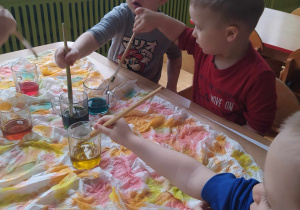 Dzieci malujące barwioną wodą.