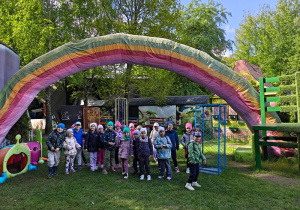 Dzieci z grupy III pozują do zdjęcia na tle kolorowej tęczy.